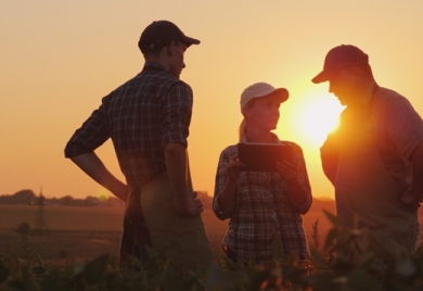 Three people discussing at sunset