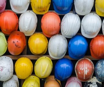 Wall of hard hats of all colors hanging up