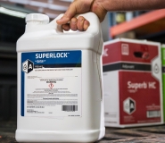A container of SuperLock™ adjuvant sits on the tailgate of a pickup truck